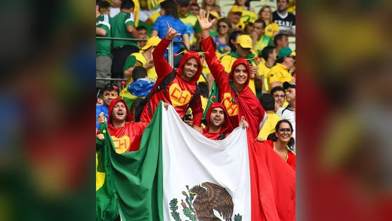 Mexico football fans celebrating in the stands with a large flag