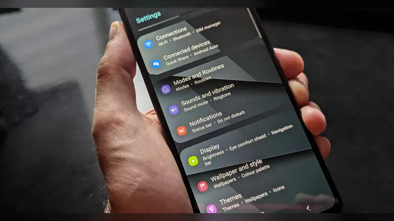 A hand holding a smartphone showing the settings screen
