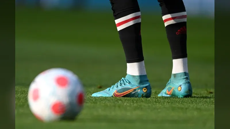 Football boots beside a ball on the grass